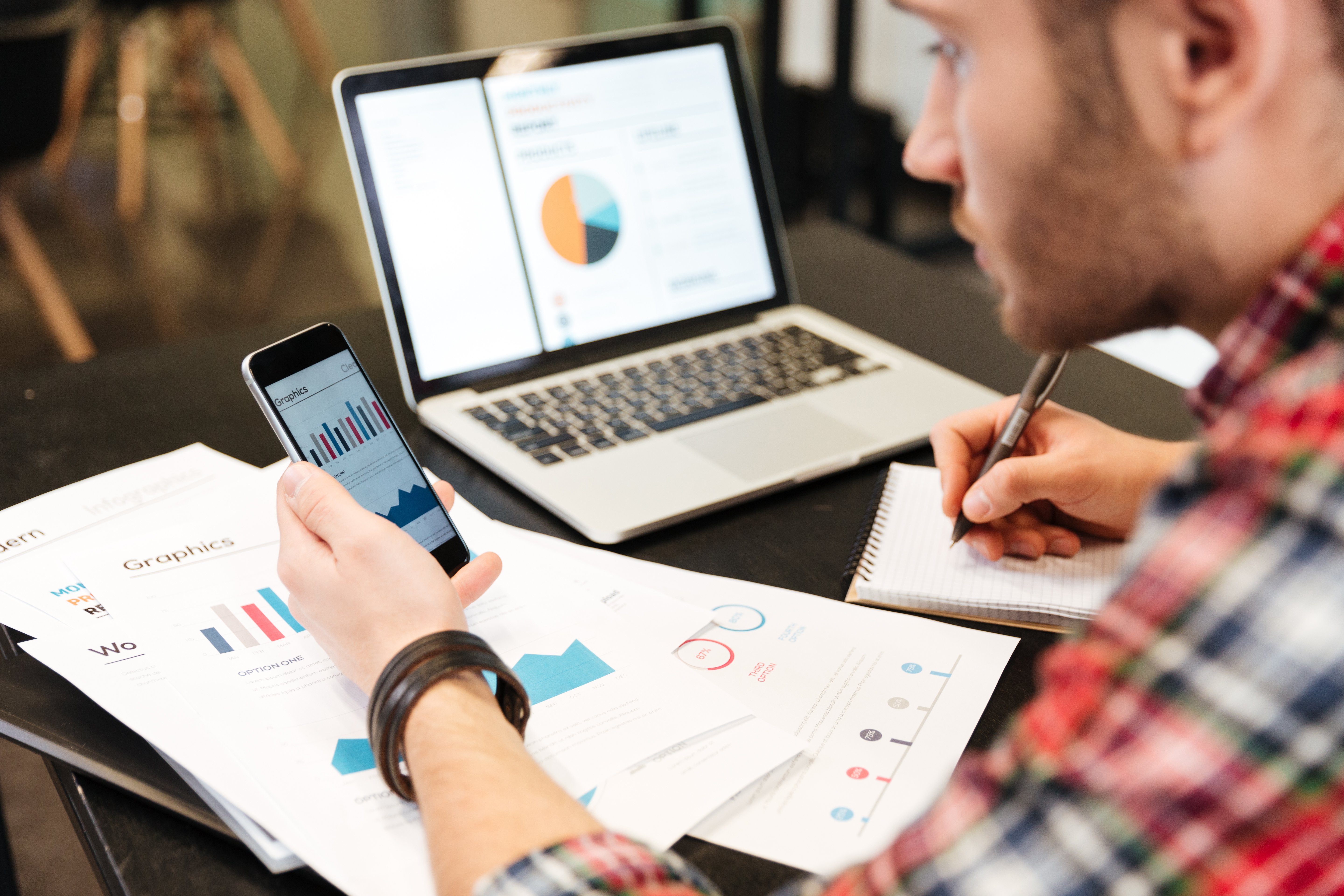 graphicstock-top-view-of-man-sitting-at-the-table-analyzes-performance-and-looking-at--SBI-302891782